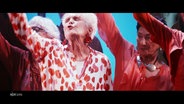 Mehrere ältere Damen singen leidenschaftlich bei einem Chorauftritt. © Screenshot 