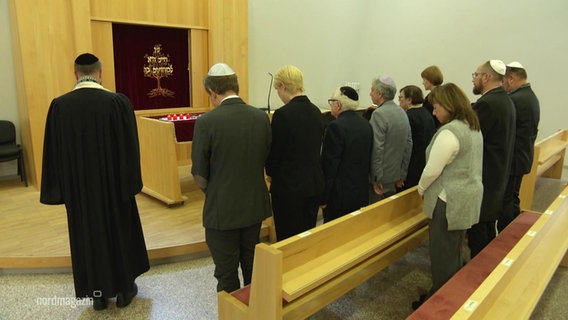 Menschen gedenken der Opfer in Israel in einer Schweriner Synagoge. © Screenshot 
