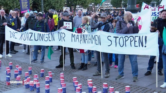 Menschen protestieren gegen Kürzungen auf dem sozialen Arbeitsmarkt. © Screenshot 