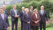 Politiker posieren für gemeinsames Foto bei Ministerpräsidenten-Konferenz. © Screenshot 