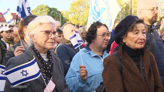Mehrere Personen bei einer Demonstration mit Israel-Flagge in der Hand. © Screenshot 