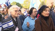 Mehrere Personen bei einer Demonstration mit Israel-Flagge in der Hand. © Screenshot 