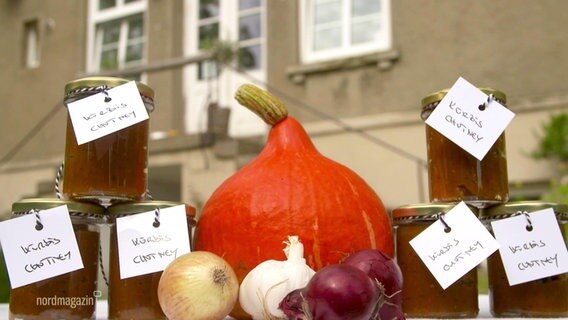 Kürbis, Zwiebel und Knoblauch sind auf einem Tisch, neben mehreren Gläsern Chutney arrangiert. © Screenshot 