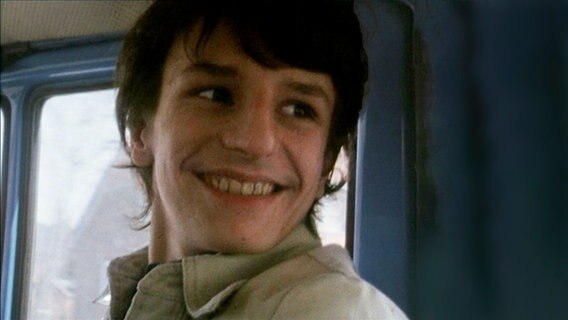 70er-Jahre-Bild: Jugendlicher sitzt in einem Bus und blickt sich lächeln um. © NDR Dokfilm 