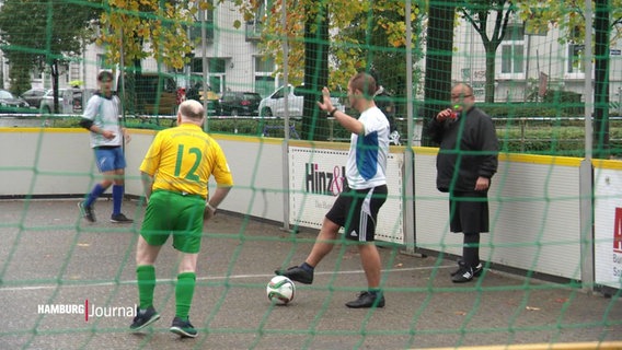 Menschen spielen Straßenfußball. © Screenshot 