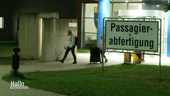 Ein Schild an einem Flughafen trägt die Aufschrift: "Passagierabfertigung". © Screenshot 