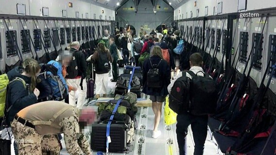 Zivilisten im Inneren eines Militärflugzeugs. © Screenshot 