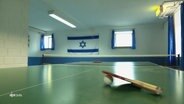 Hinter einer Tischtennisplatte hängt die Fahne Israels. © Screenshot 