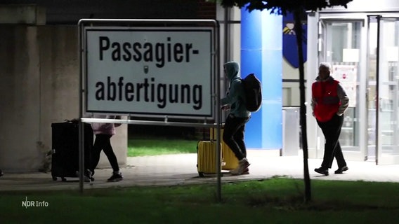 An einem Flughafen steht ein Schild mit der Aufschrift: "Passagierabfertigung". © Screenshot 