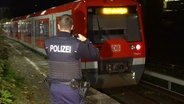 Eine stehende S-Bahn, im Vordergrund ein Polizist von hinten. © Screenshot 