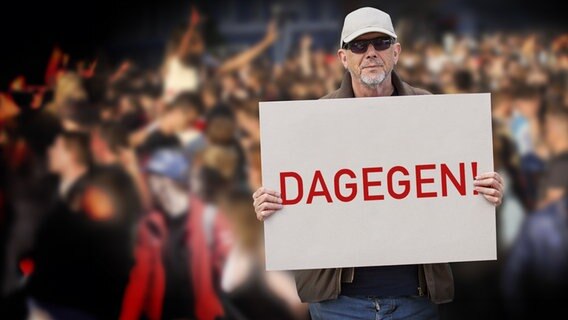 Ein Mann mit einem Schild, auf dem "Dagegen" steht. (extra 3 vom 19.10.2023 im Ersten) © NDR 
