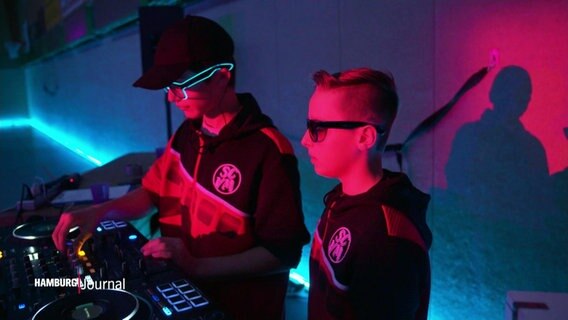 Zwei junge DJs stehen an einem Mischpult. © Screenshot 
