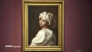 Das Portrait einer Frau mit einem weißen Turban hängt an einer weinroten Wand. © Screenshot 
