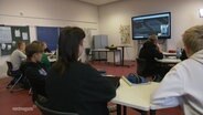 Schüler*innen sitzen in einem Klassenraum. © Screenshot 