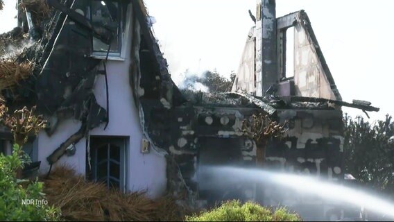 Ein abgebranntes Haus wird von der Feuerwehr gelöscht. © Screenshot 
