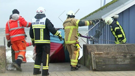 Feuerwehrleute bringen Boote aus der Ostsee ans Land. © Screenshot 