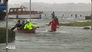 Während einer Sturmflut werden einige Männer in einem Boot gezogen. © Screenshot 