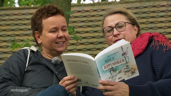 Autorin Susanne Bliemel und Illustratorin Silke Herr mit ihrem Buch "Nieges ut Hoppenhagen". © Screenshot 