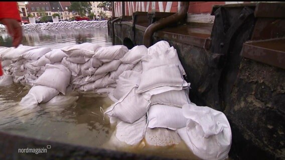 Sandsäcke halten Hochwasser von einer historischen Mauer in Wismar fern. © Screenshot 