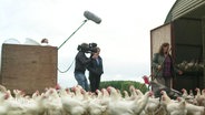Eine Frau wird auf ihrem Hof von einem Kamera-Team gefilmt. © Screenshot 