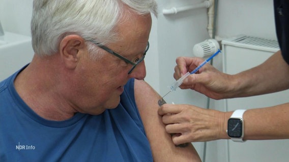 Ein älterer Herr wird in den Oberarm geimpft. © Screenshot 