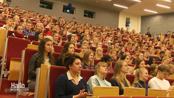 Ein Hörsaal in dem viele Menschen sitzen. © Screenshot 