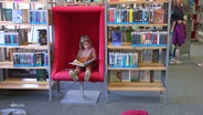 Ein Kind sitzt in einem Sessel und liest. © Screenshot 