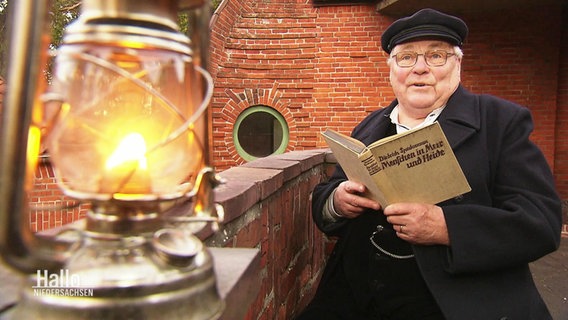 Geschichtenerzähler Klaus Meyer hält ein Buch in den Händen. © Screenshot 