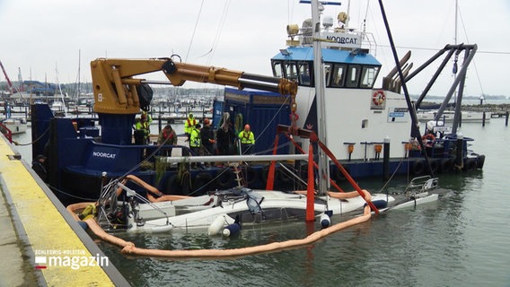 Im Hafen von Schilksee wird ein gesunkenes Sportboot geborgen. © Screenshot 