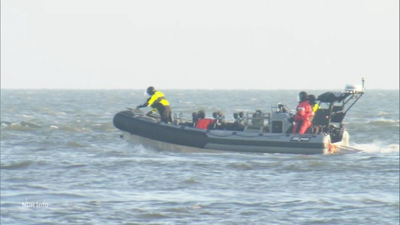 Mehrere Personen sind in einem motorisierten Schlauchboot auf dem Meer. © Screenshot 