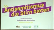 Projektion einer Überschrift bei der Beteiligungskonferenz Aktionsplan gegen Antisemitismus: "Antisemitismus die Stirn bieten". © Screenshot 