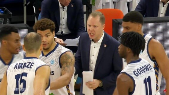 Basketball-Spieler in der Pause mit ihrem Trainer. © Screenshot 