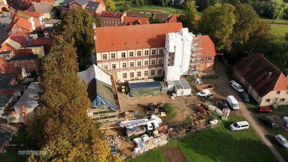 Blick aus der Vogelperspektive auf ein Grundstück eines älteren Herrenhauses an dessen Fassade ein Baugeländer steht. © Screenshot 