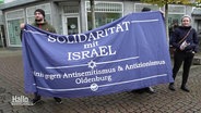 Zwei Menschen halten einen Banner mit der Aufschrift "Solidarität mit Israel" © Screenshot 