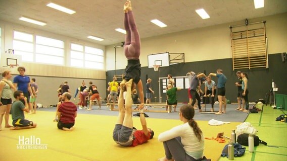 Menschen in einer Halle, die turnen. © Screenshot 