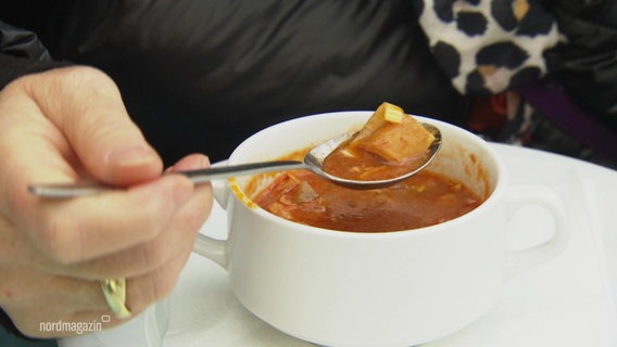 Eine Schale mit Suppe und ein Löffel auf dem etwas von der Suppe ist. © Screenshot 