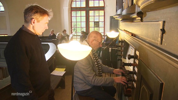 Ein Organist spielt eine Orgel. © Screenshot 