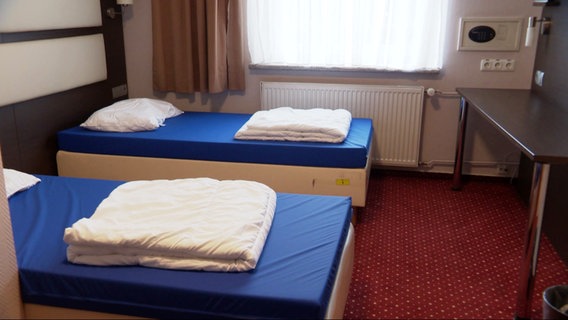 Frisch bezogenene Betten in einem Zimmer des WInternotprogramms für wohnungslose Menschen. © Screenshot 