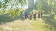 Bild aus dem Eröffnungsfilm der 65. Nordischen Filmtage: Eine Gruppe Erwachsener in einem grünen Garten, sie decken einen Tisch.  Als Untertext zu lesen der Satz: "I have to say that this is amazing!" © Screenshot 