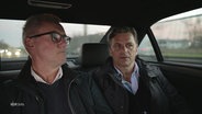 .Dirk Schlegel und Falko Götz auf der Rückbank eines Autos. © Screenshot 