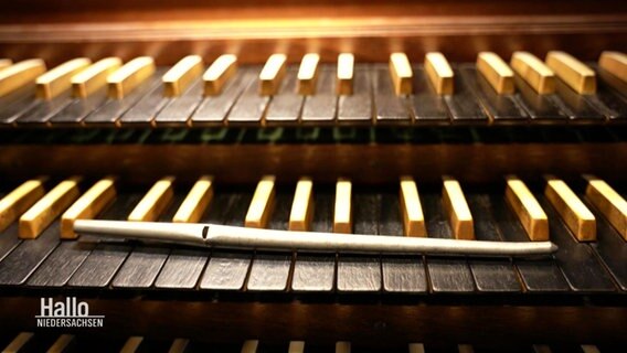 Eine Orgelpfeife liegt auf Orgeltasten. © Screenshot 