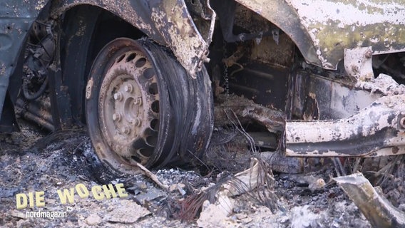 Blick auf die komplett abgebrannte Flanke eines Autos. © Screenshot 