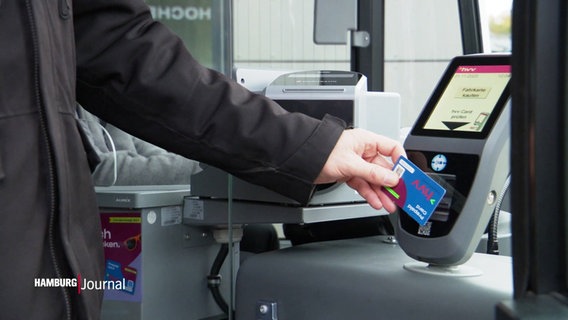 Eine Person hält in einem Linienbus eine Karte des öffentlichen Nahverkehrs hvv an eine Art Scanner. © Screenshot 