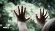 Kinderhände an einer Glasscheibe. © Screenshot 
