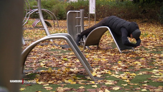 Eine Person macht Sportübungen auf einem Trimm-dich-Gerät an der Außenalster. © Screenshot 