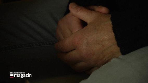 Im Schoß gefaltete Hände einer Person. © Screenshot 