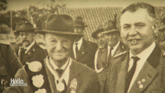 Ein altes Foto zweier Männer mit Hüten und mit Orden beschmückten Jacken. © Screenshot 