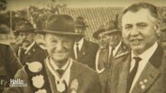 Ein altes Foto zweier Männer mit Hüten und mit Orden beschmückten Jacken. © Screenshot 