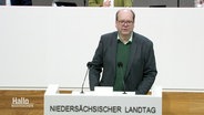 Der niedersächsische Umweltminister, Christian Meyer von den Grünen, steht an einem Redepult im Landtag. © Screenshot 