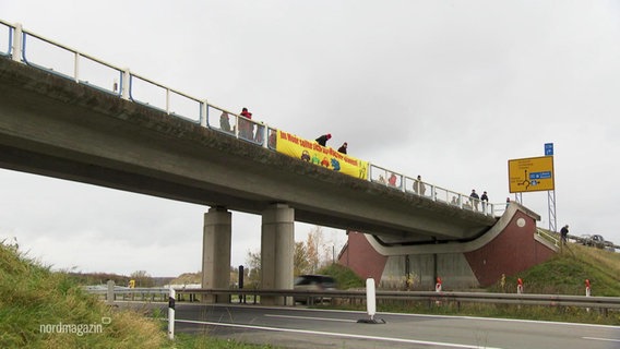 Auf einer Autobahnbrücke haben Aktivisten ein Banner angebracht. © Screenshot 